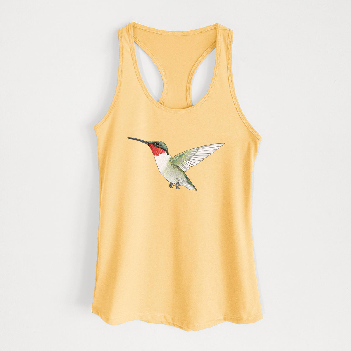 Banana cream women's racerback tank top laid flat, printed with a full-color illustration of a ruby-throated hummingbird in flight.
