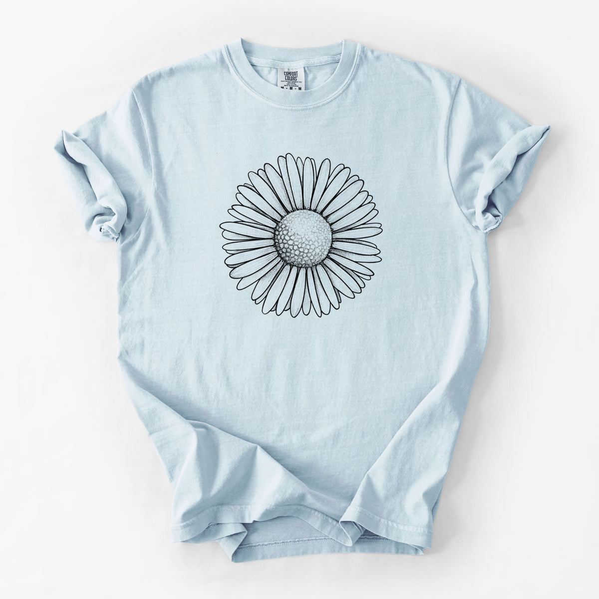 Chambray blue Comfort Colors t-shirt laid flat, printed with a detailed black ink line drawing of a single common daisy flower.