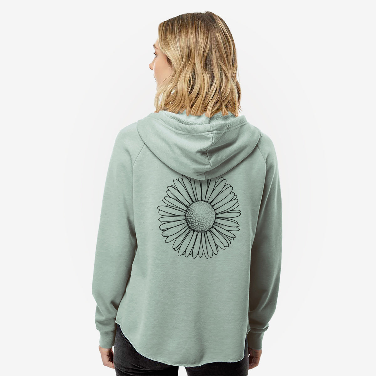 Woman wearing a sage green women's Cali Wave zip-up sweatshirt printed with a detailed black ink line drawing of a single common daisy flower, seen from behind.