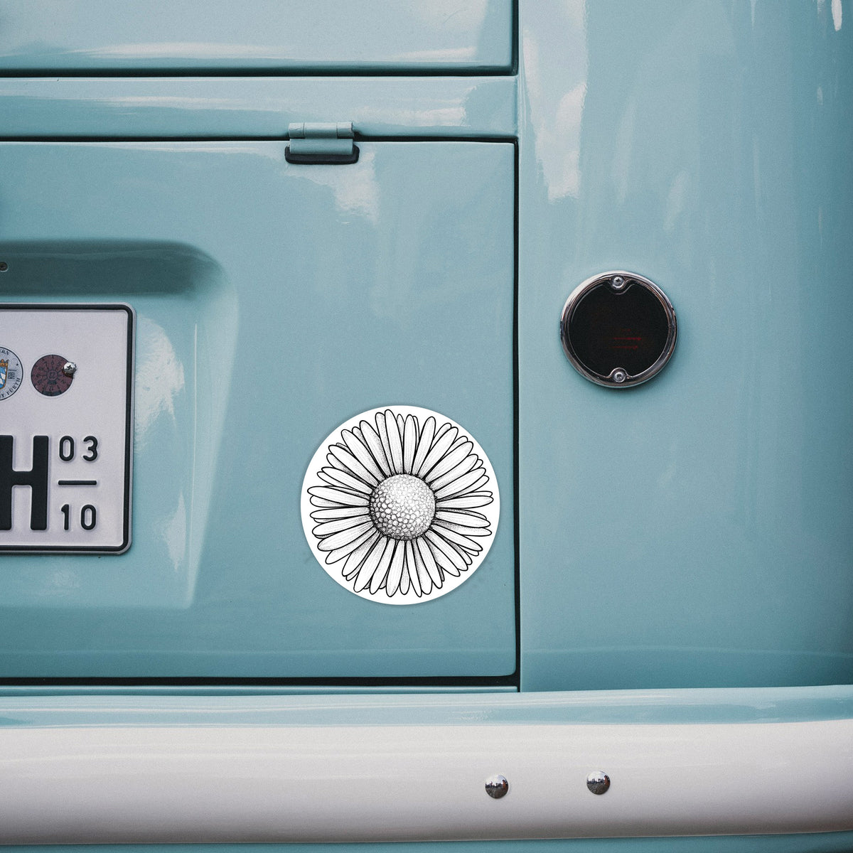 4 inch vinyl decal of a detailed black ink line drawing of a single common daisy flower on the back of a van.