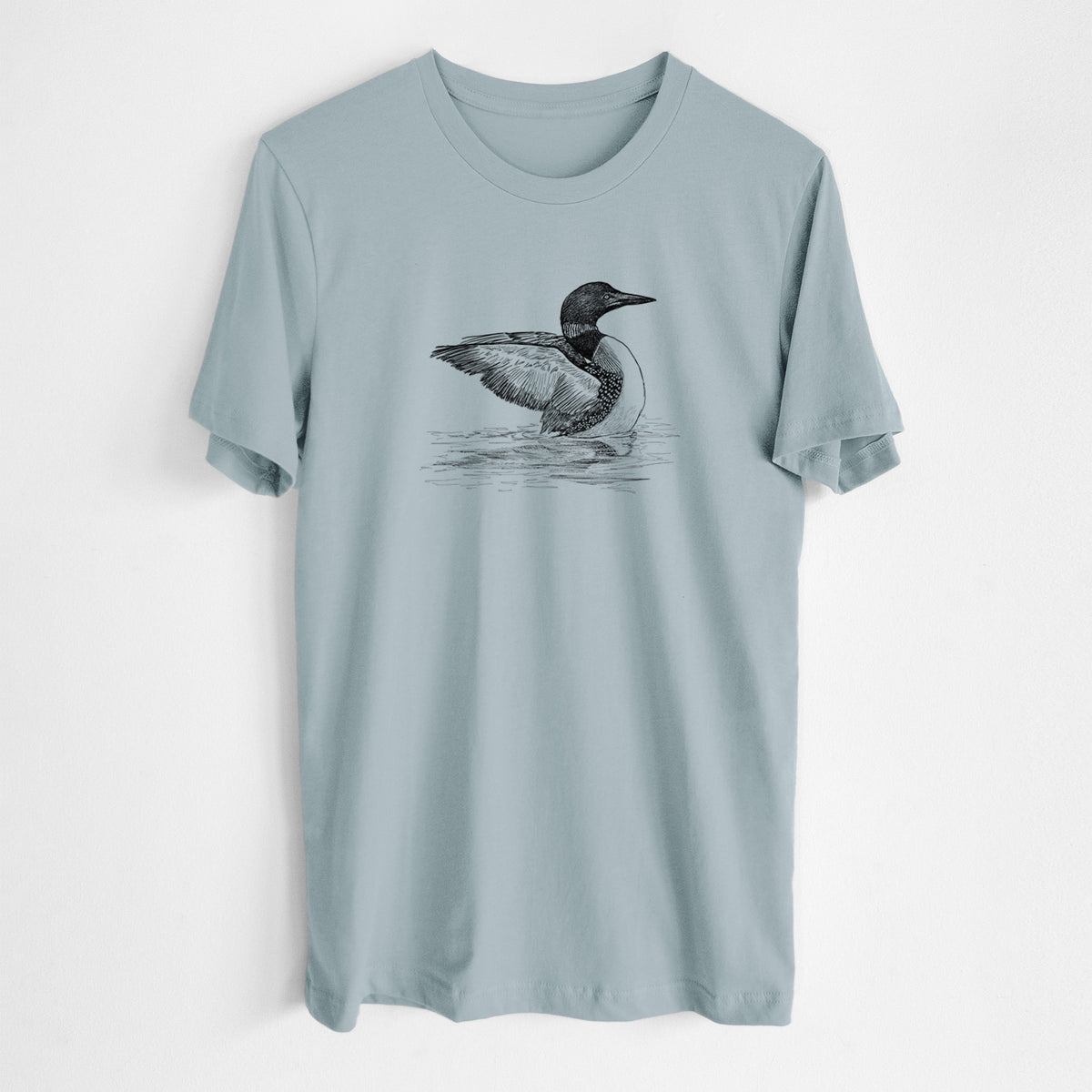 Vintage denim lightweight cotton t-shirt laid flat, printed with a detailed black ink sketch of a common loon floating on rippling water.