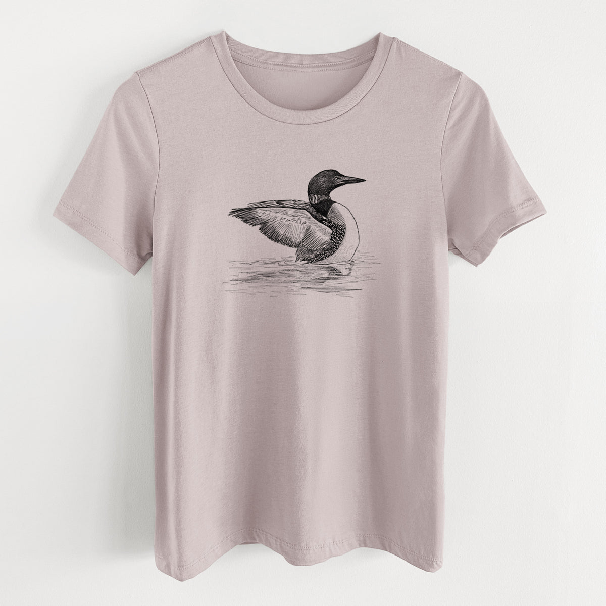 Pink gravel women's relaxed fit cotton t-shirt laid flat, printed with a detailed black ink sketch of a common loon floating on rippling water.