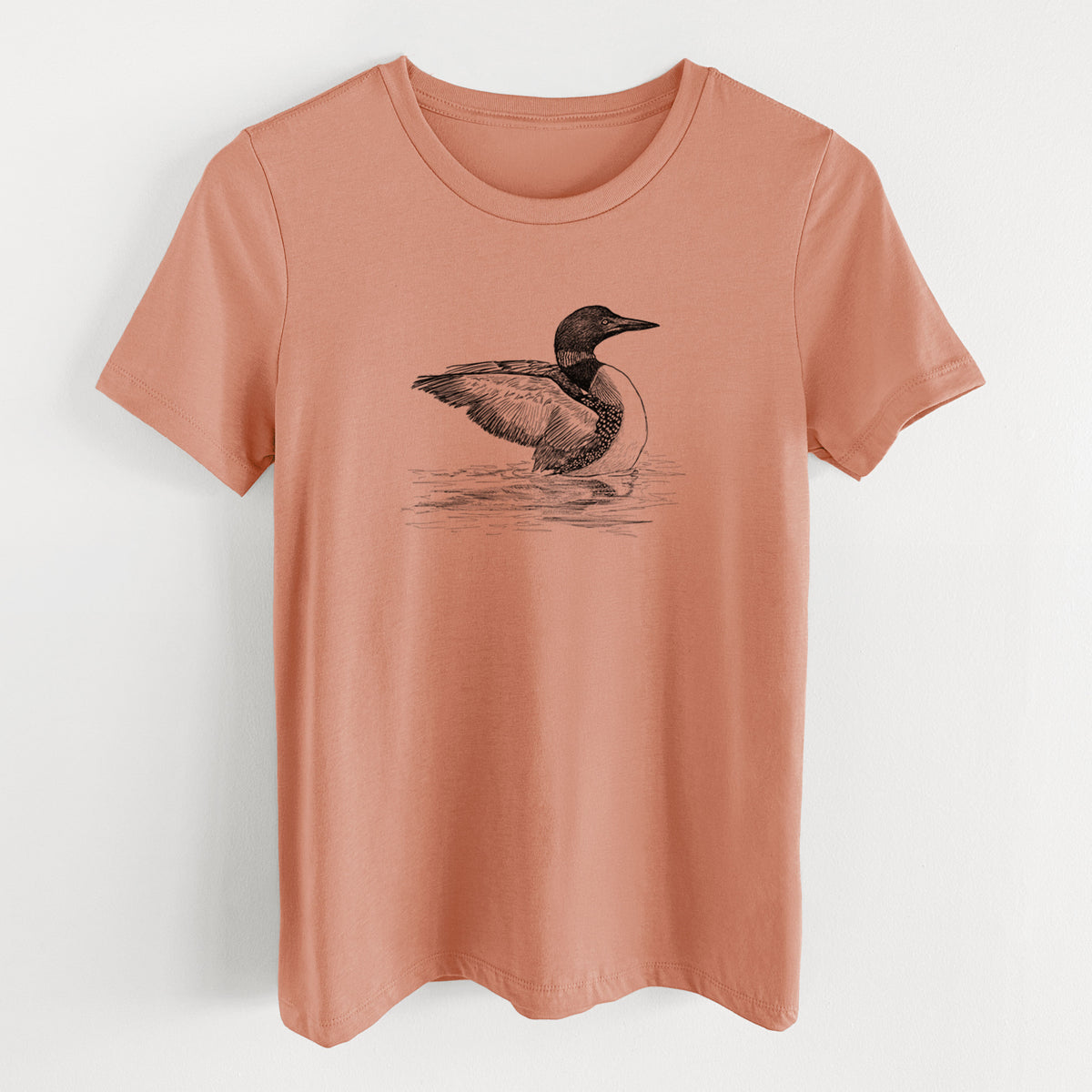 Terracotta orange women's relaxed fit cotton t-shirt laid flat, printed with a detailed black ink sketch of a common loon floating on rippling water.