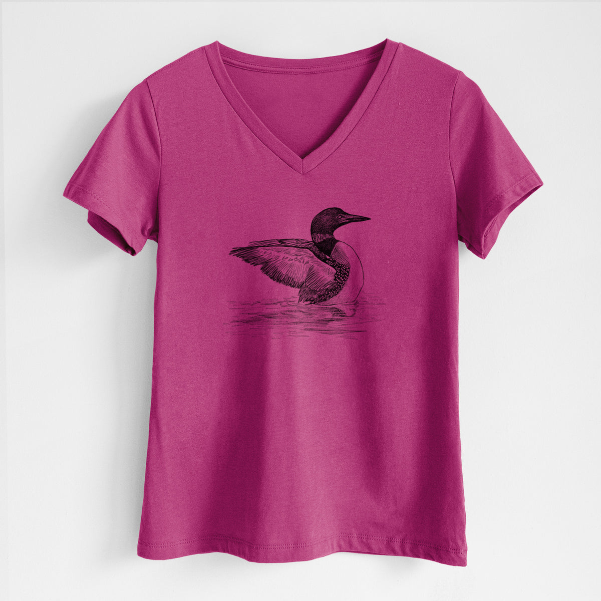 Berry pink women's relaxed fit cotton V-neck t-shirt laid flat, printed with a detailed black ink sketch of a common loon floating on rippling water.