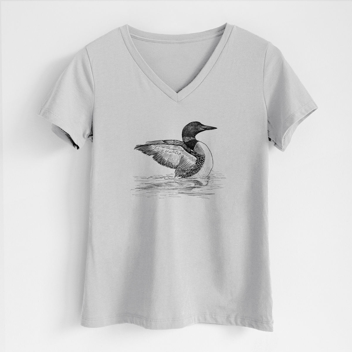 Lunar grey women's relaxed fit cotton V-neck t-shirt laid flat, printed with a detailed black ink sketch of a common loon floating on rippling water.