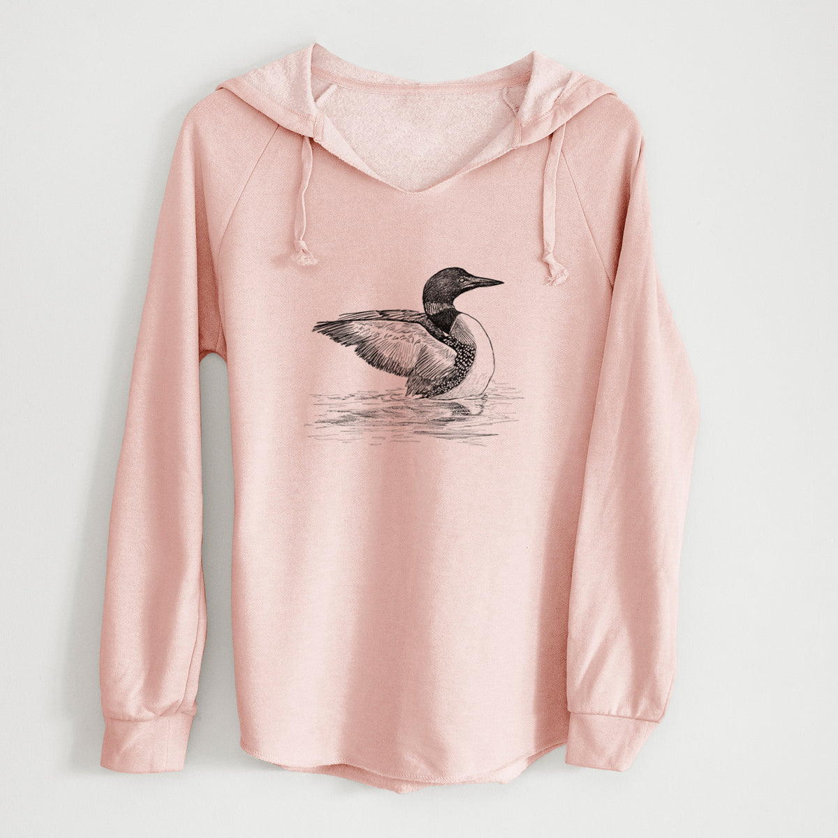 Blush pink women's Cali Wave hooded sweatshirt laid flat, printed with a detailed black ink sketch of a common loon floating on rippling water.