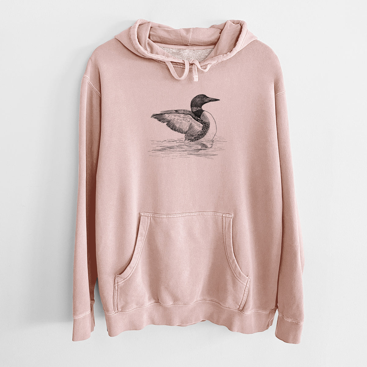 Dusty pink pigment dyed hoodie laid flat, printed with a detailed black ink sketch of a common loon floating on rippling water.