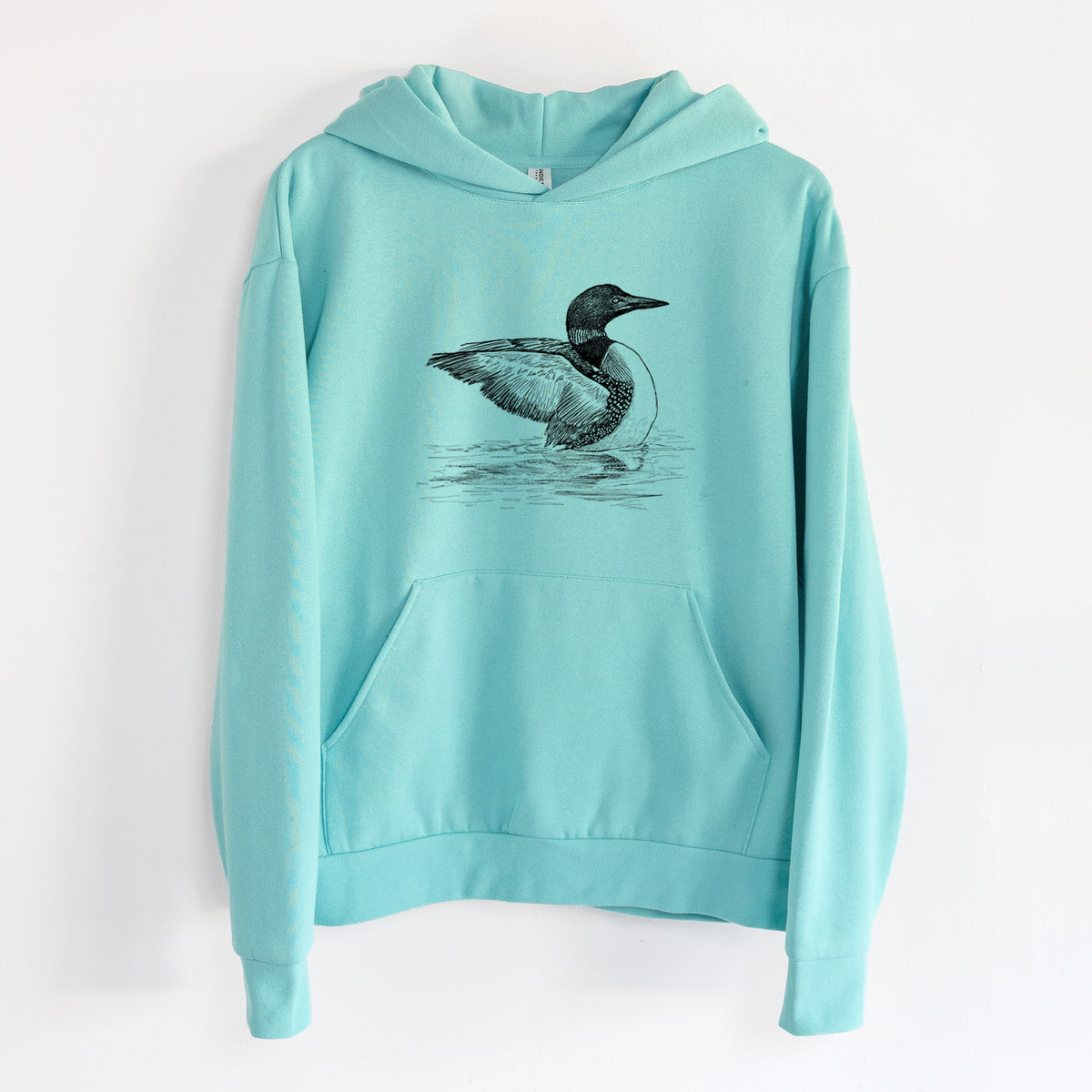 Common Loon - Gavia immer - Statement Midweight Hoodie in Seafoam, hanging on a white wall, with a front kangaroo pocket and no drawcords.