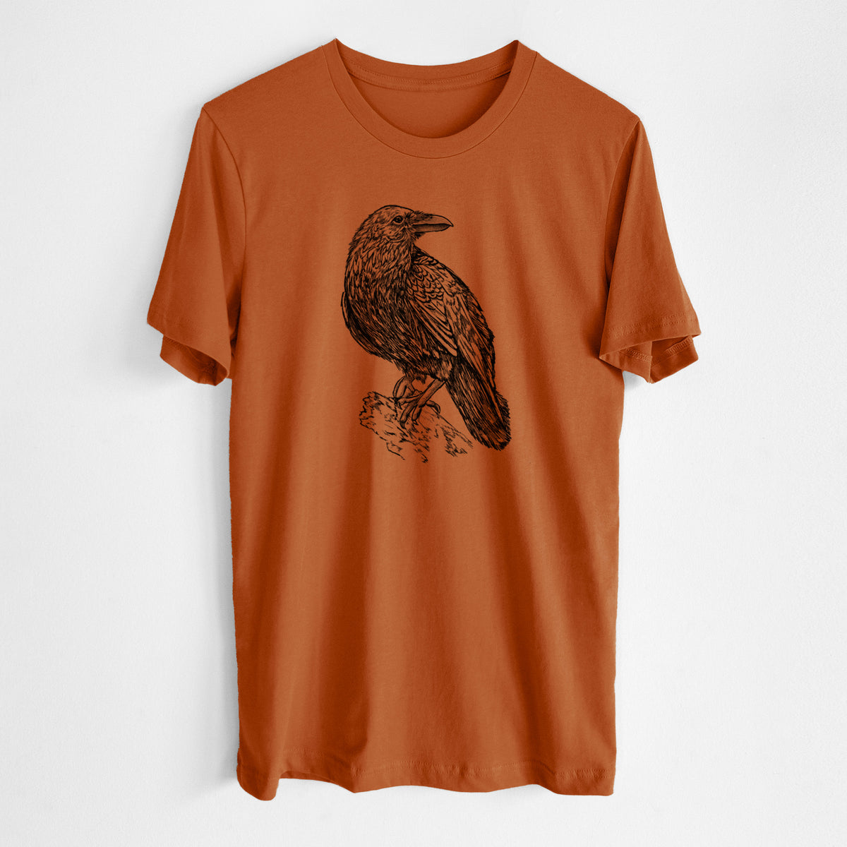 Autumn lightweight cotton t-shirt laid flat, printed with a detailed black ink sketch of a common raven perched on a rock.