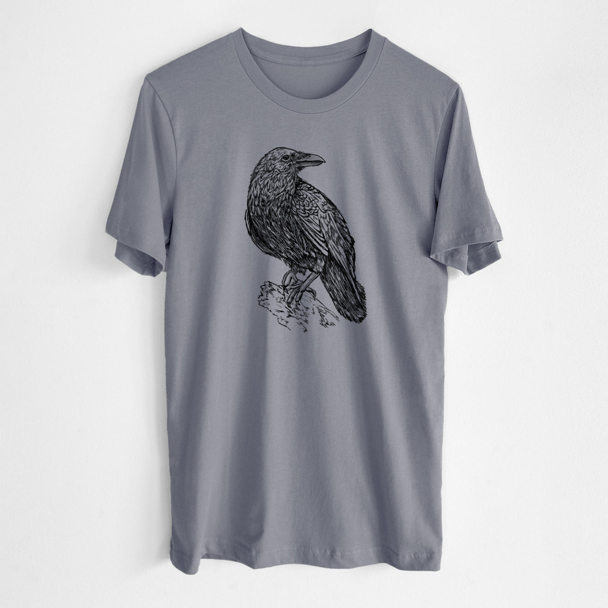 Storm grey lightweight cotton t-shirt laid flat, printed with a detailed black ink sketch of a common raven perched on a rock.