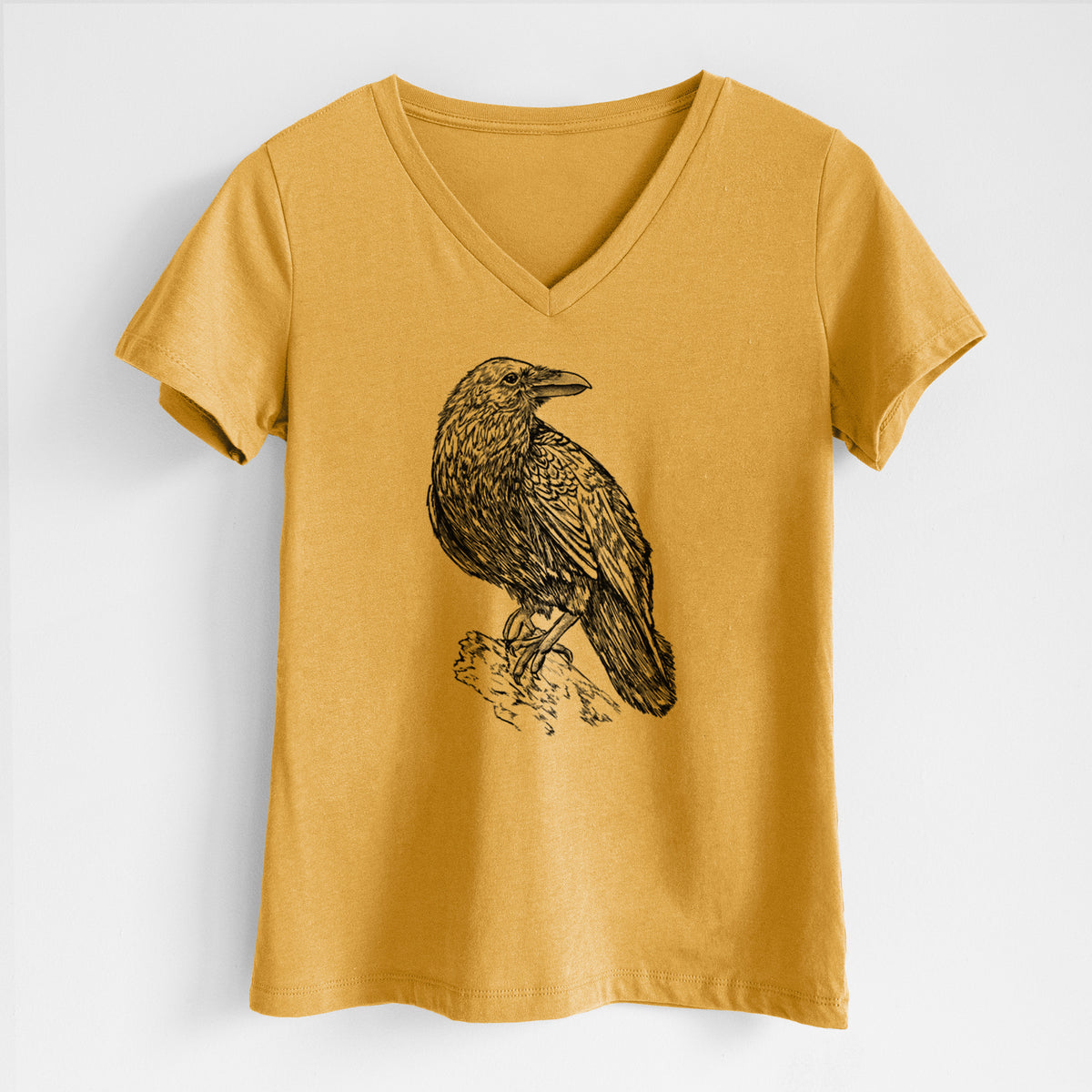 Honeycomb yellow women's relaxed fit cotton V-neck t-shirt laid flat, printed with a detailed black ink sketch of a common raven perched on a rock.
