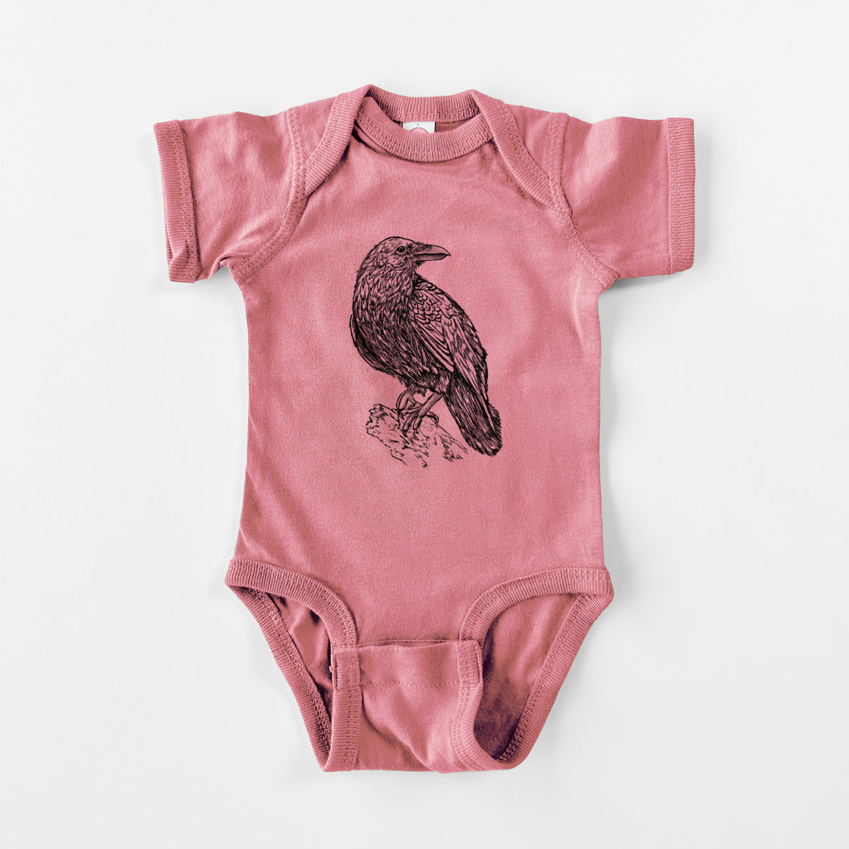 Mauve pink baby bodysuit laid flat, printed with a detailed black ink sketch of a common raven perched on a rock.