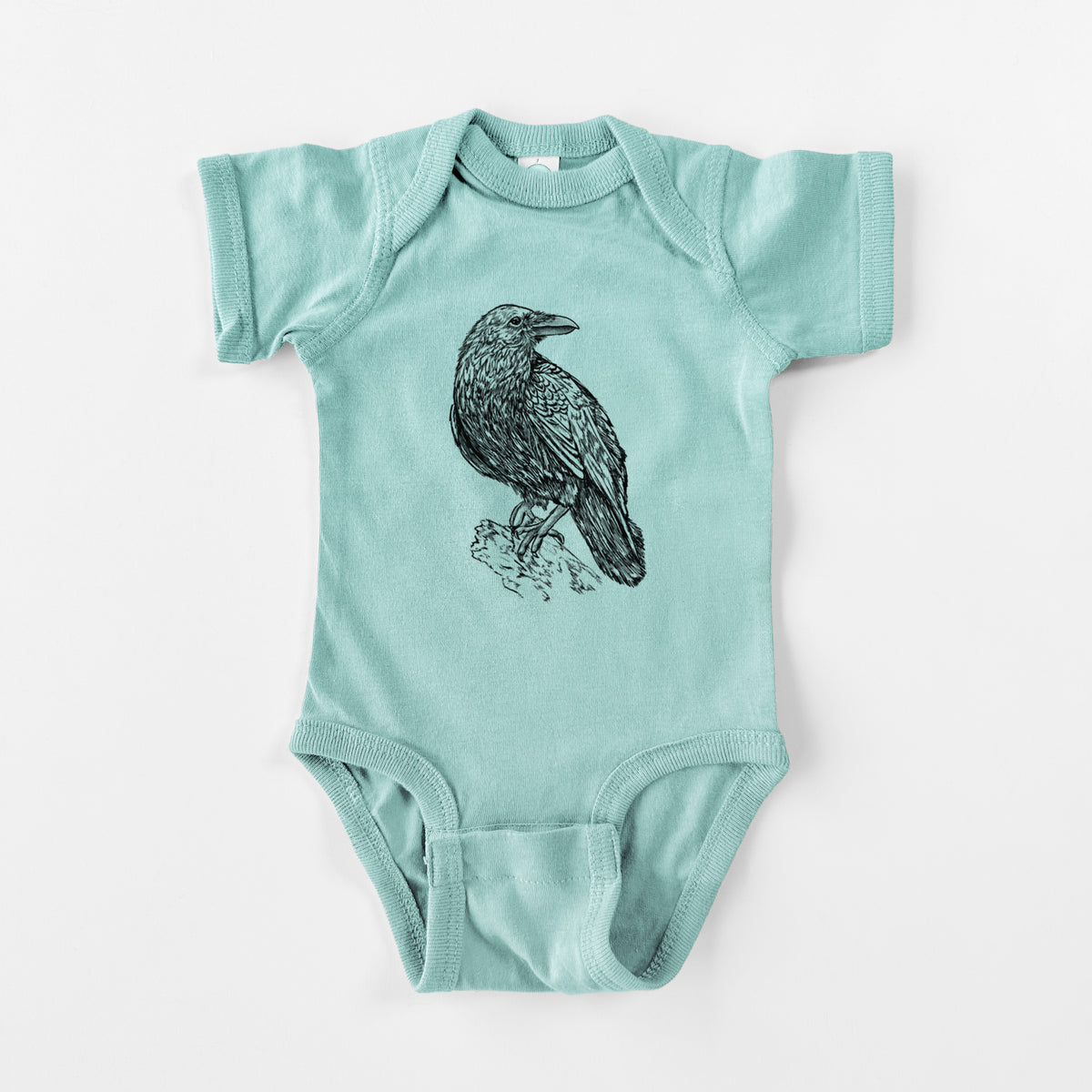 Saltwater baby bodysuit laid flat, printed with a detailed black ink sketch of a common raven perched on a rock.