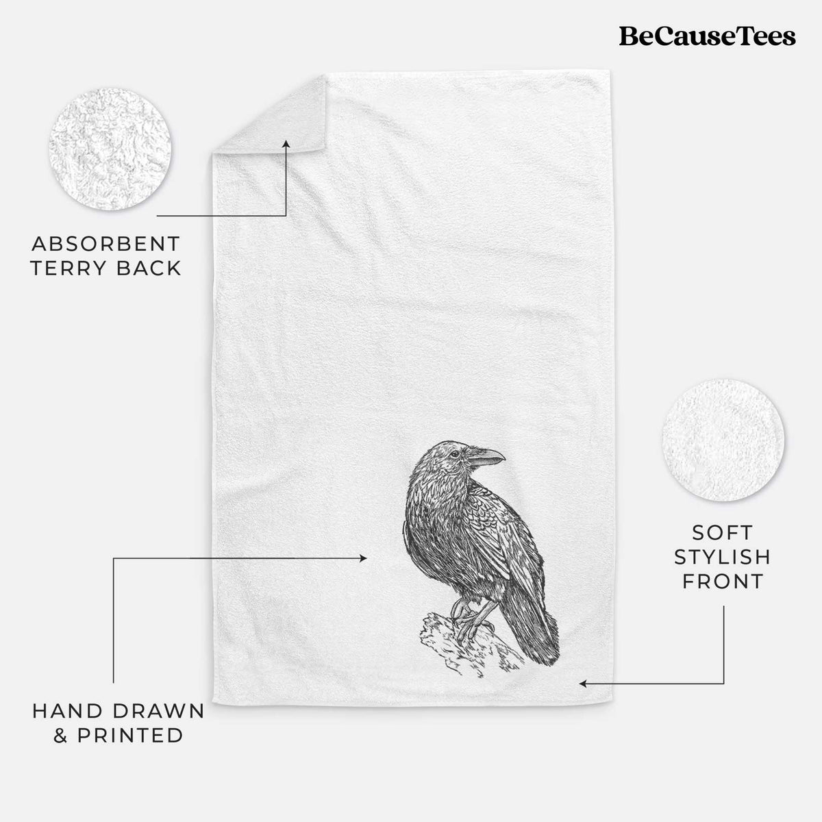 White hand towel printed with a detailed black ink sketch of a common raven perched on a rock.