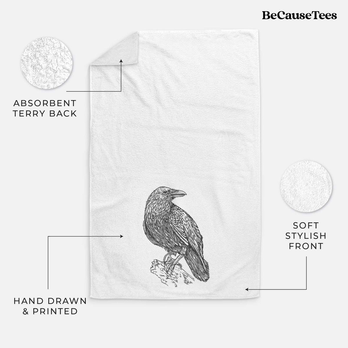 White hand towel printed with a detailed black ink sketch of a common raven perched on a rock.