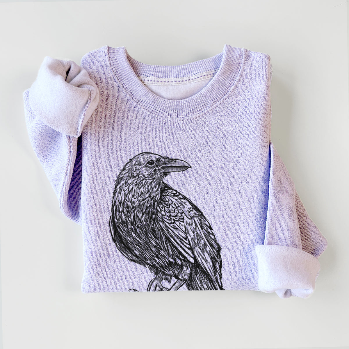 Ice purple knit sweatshirt printed with a detailed black ink sketch of a common raven perched on a rock, styled flat.