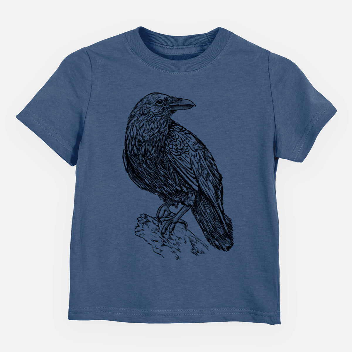 Indigo blue toddler t-shirt laid flat, printed with a detailed black ink sketch of a common raven perched on a rock.