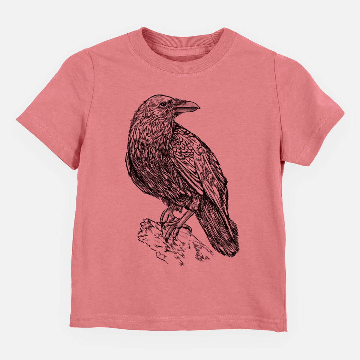 Mauve pink toddler t-shirt laid flat, printed with a detailed black ink sketch of a common raven perched on a rock.