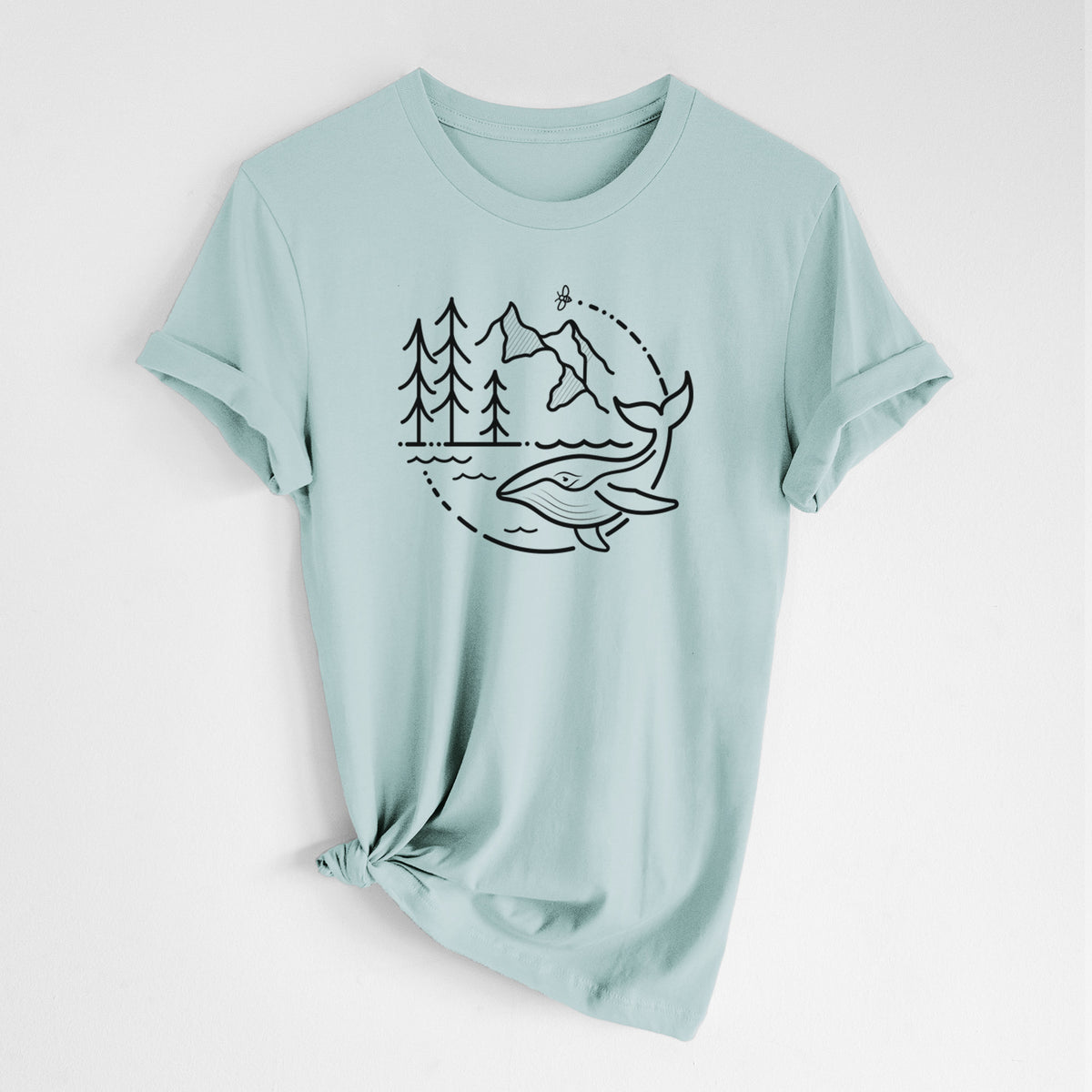 Dusty blue lightweight cotton t-shirt laid flat with the sleeves rolled, printed with a black line art circle connecting a mountain range, pine trees, a bee and a whale swimming in ocean waves.