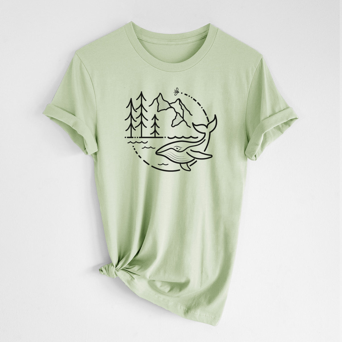 Spring green lightweight cotton t-shirt laid flat with the sleeves rolled, printed with a black line art circle connecting a mountain range, pine trees, a bee and a whale swimming in ocean waves.