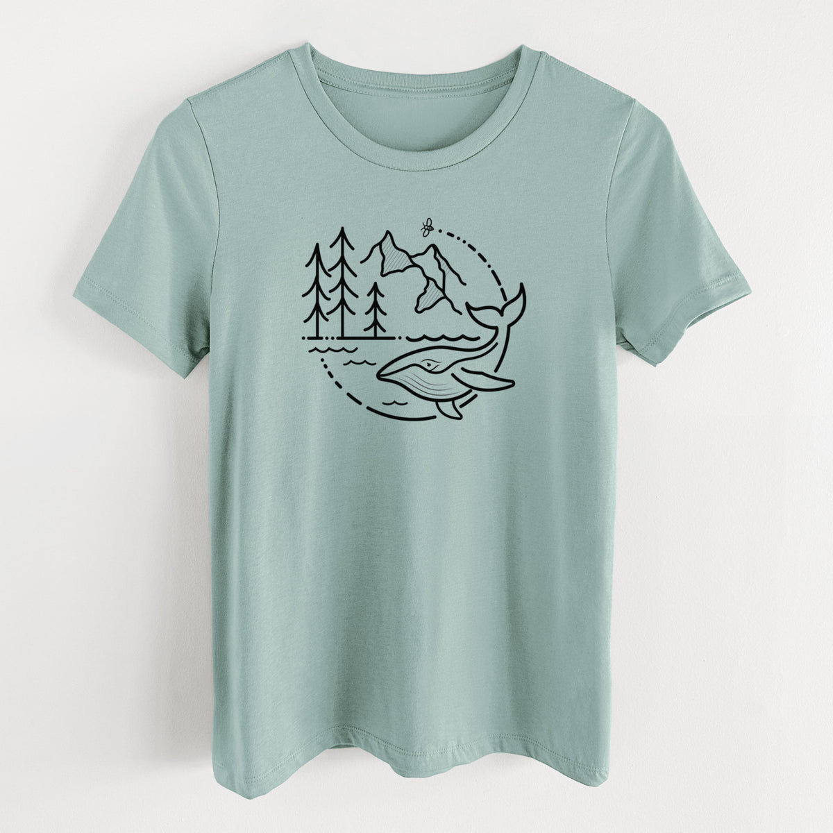 Dusty blue women's relaxed fit cotton t-shirt laid flat, printed with a black line art circle connecting a mountain range, pine trees, a bee and a whale swimming in ocean waves.