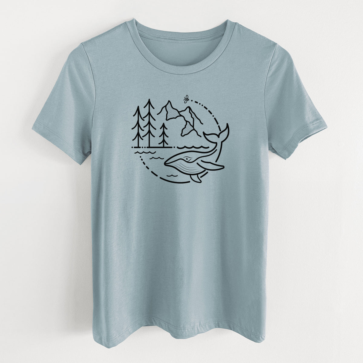 Vintage denim women's relaxed fit cotton t-shirt laid flat, printed with a black line art circle connecting a mountain range, pine trees, a bee and a whale swimming in ocean waves.