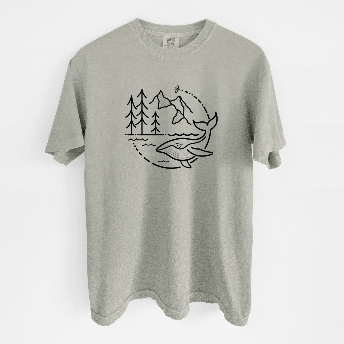 Sandstone beige Comfort Colors t-shirt laid flat, printed with a black line art circle connecting a mountain range, pine trees, a bee and a whale swimming in ocean waves.