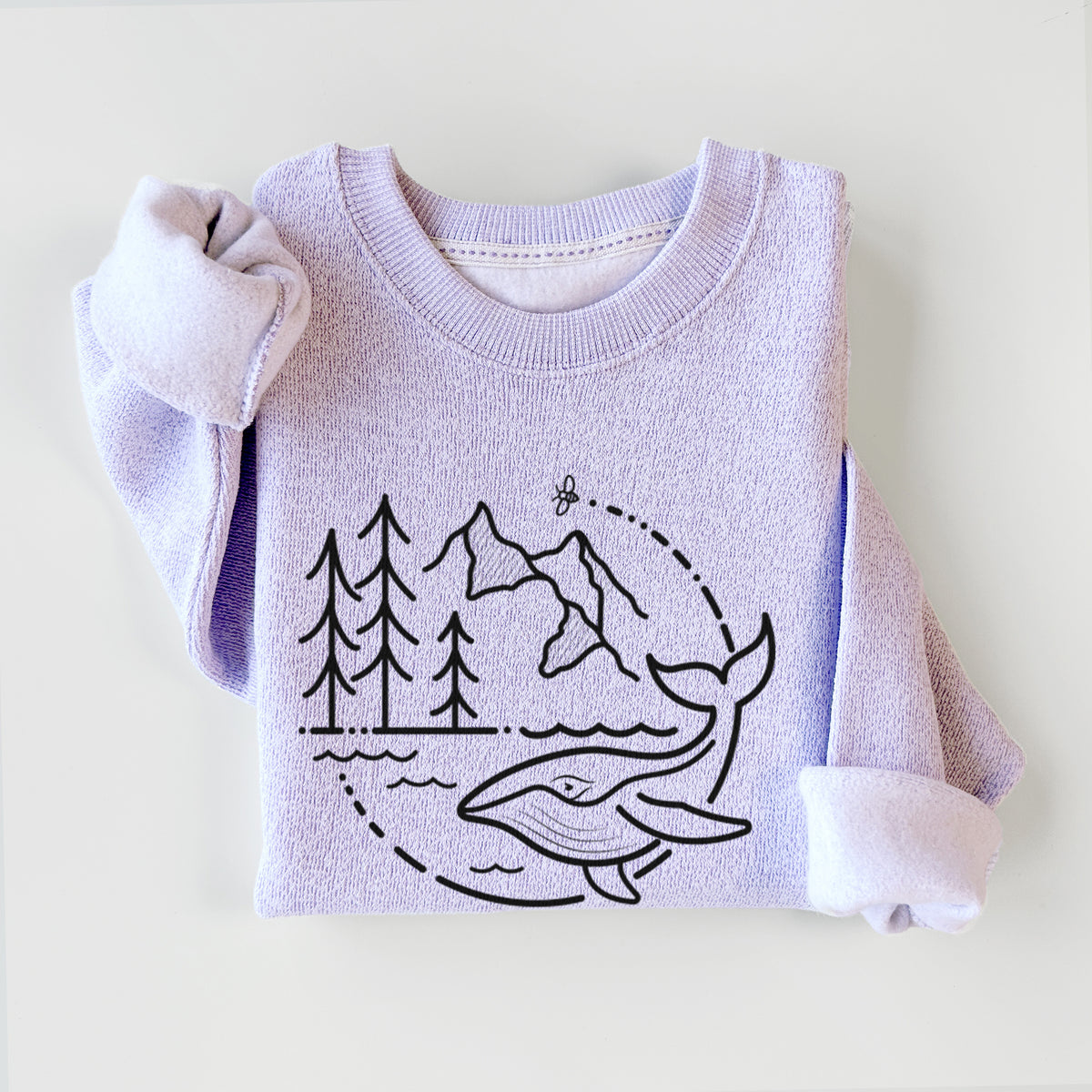 Ice purple knit sweatshirt printed with a black line art circle connecting a mountain range, pine trees, a bee and a whale swimming in ocean waves, styled flat.