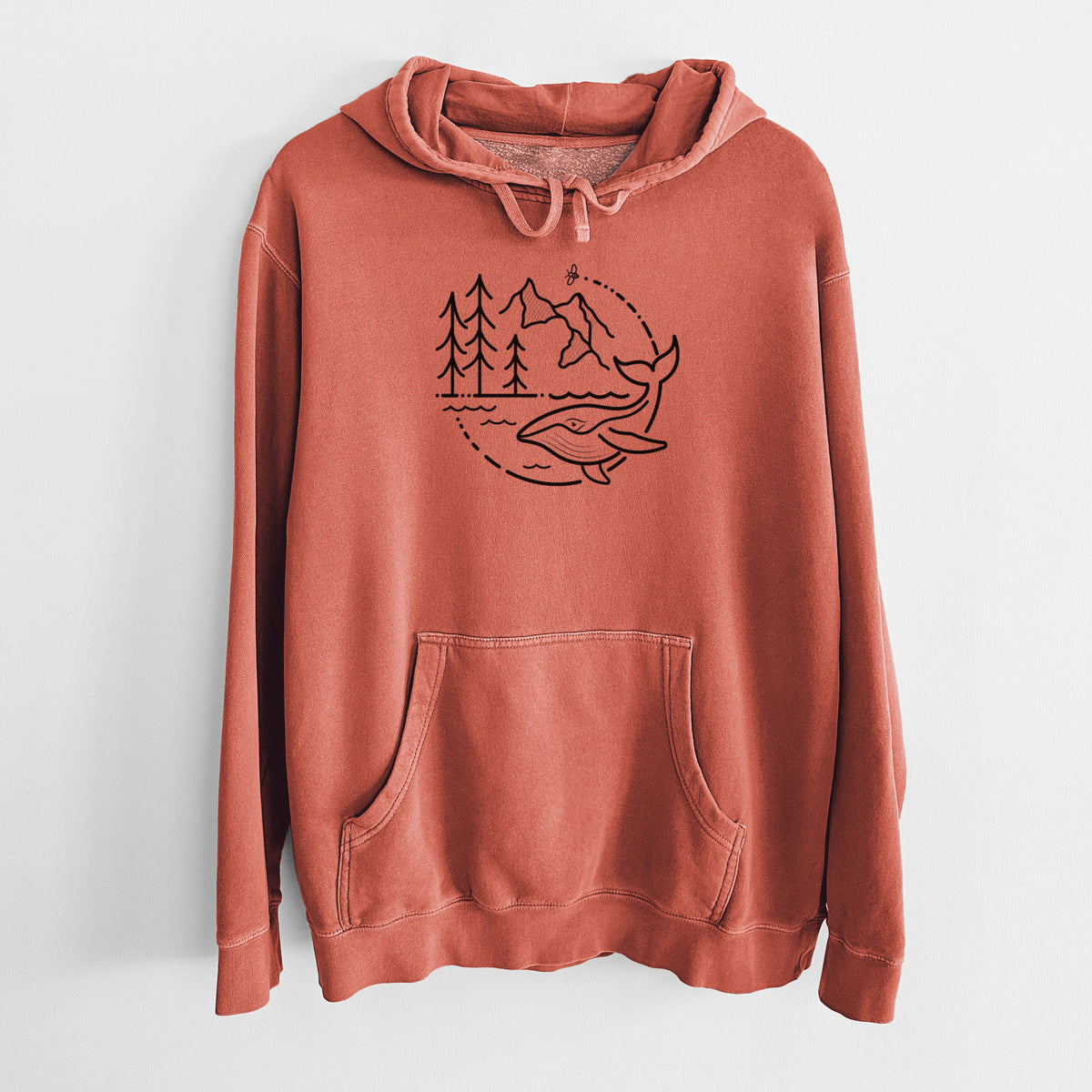Amber orange pigment dyed hoodie laid flat, printed with a black line art circle connecting a mountain range, pine trees, a bee and a whale swimming in ocean waves.