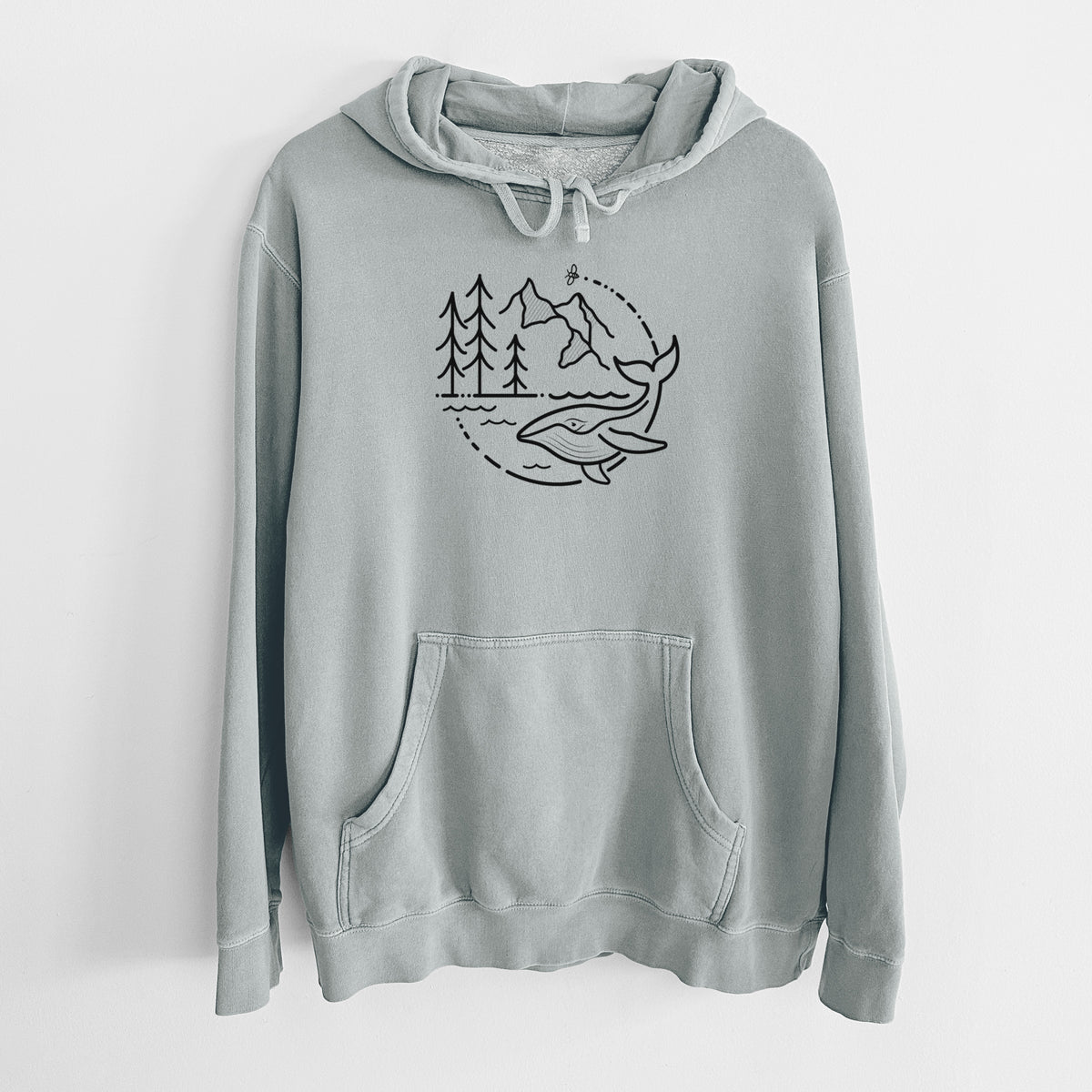 Sage green pigment dyed hoodie laid flat, printed with a black line art circle connecting a mountain range, pine trees, a bee and a whale swimming in ocean waves.