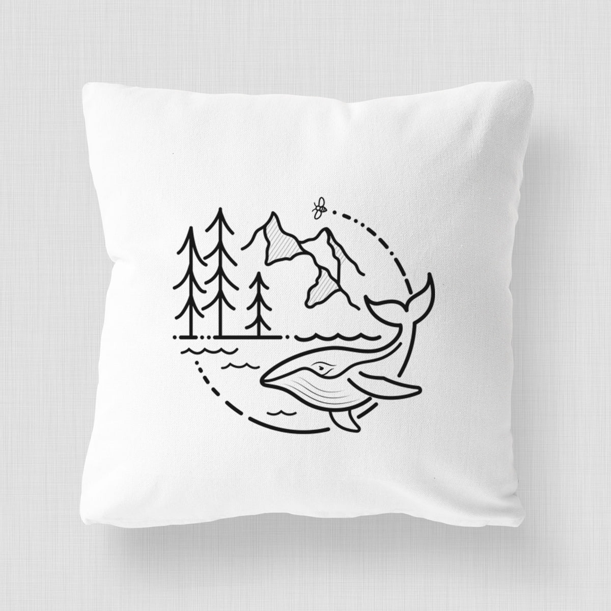 White pillow cover printed with a black line art circle connecting a mountain range, pine trees, a bee and a whale swimming in ocean waves.