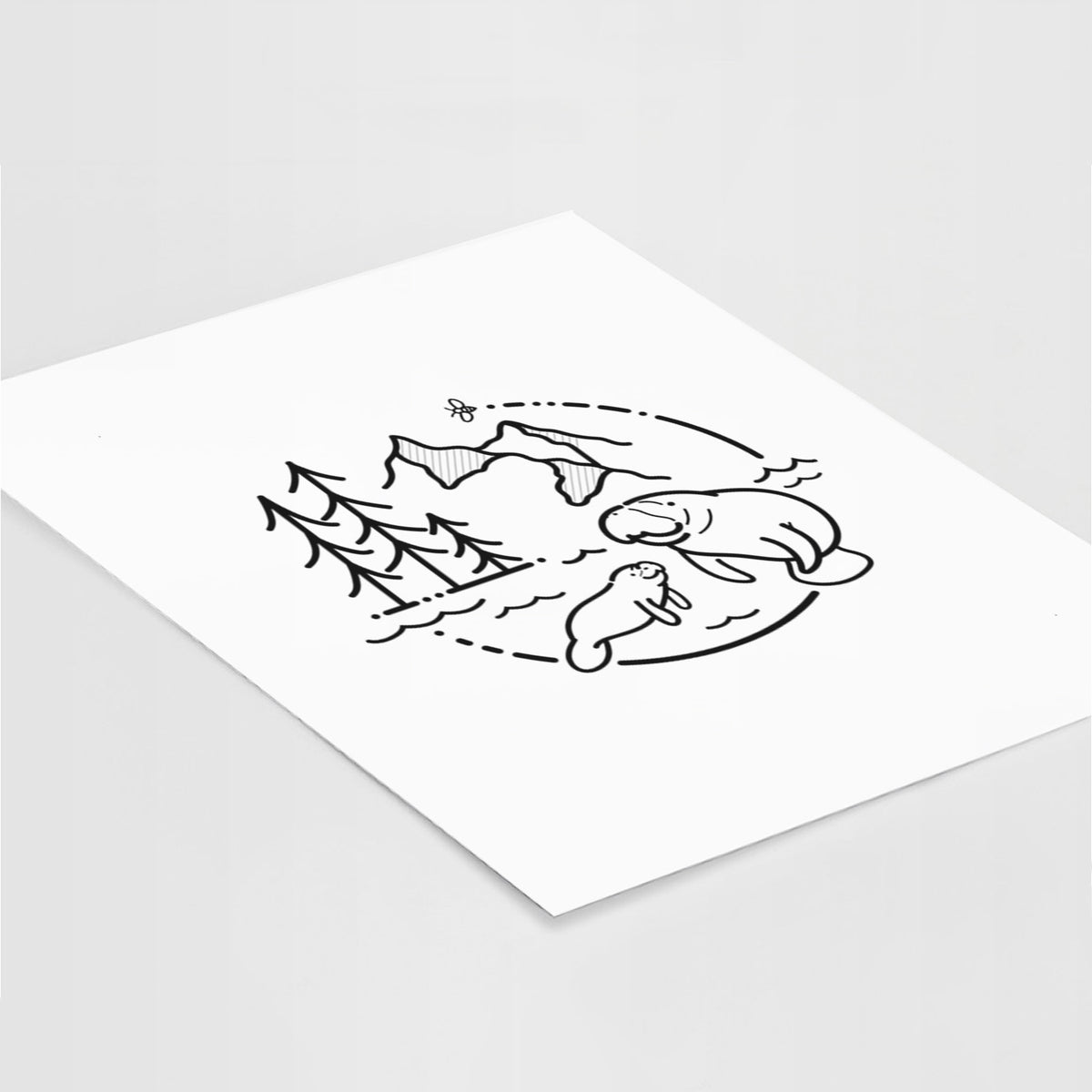 Art print of a black line art circle connecting pine trees, mountains, a bee and two manatees swimming in water, lying at an angle on a white surface.
