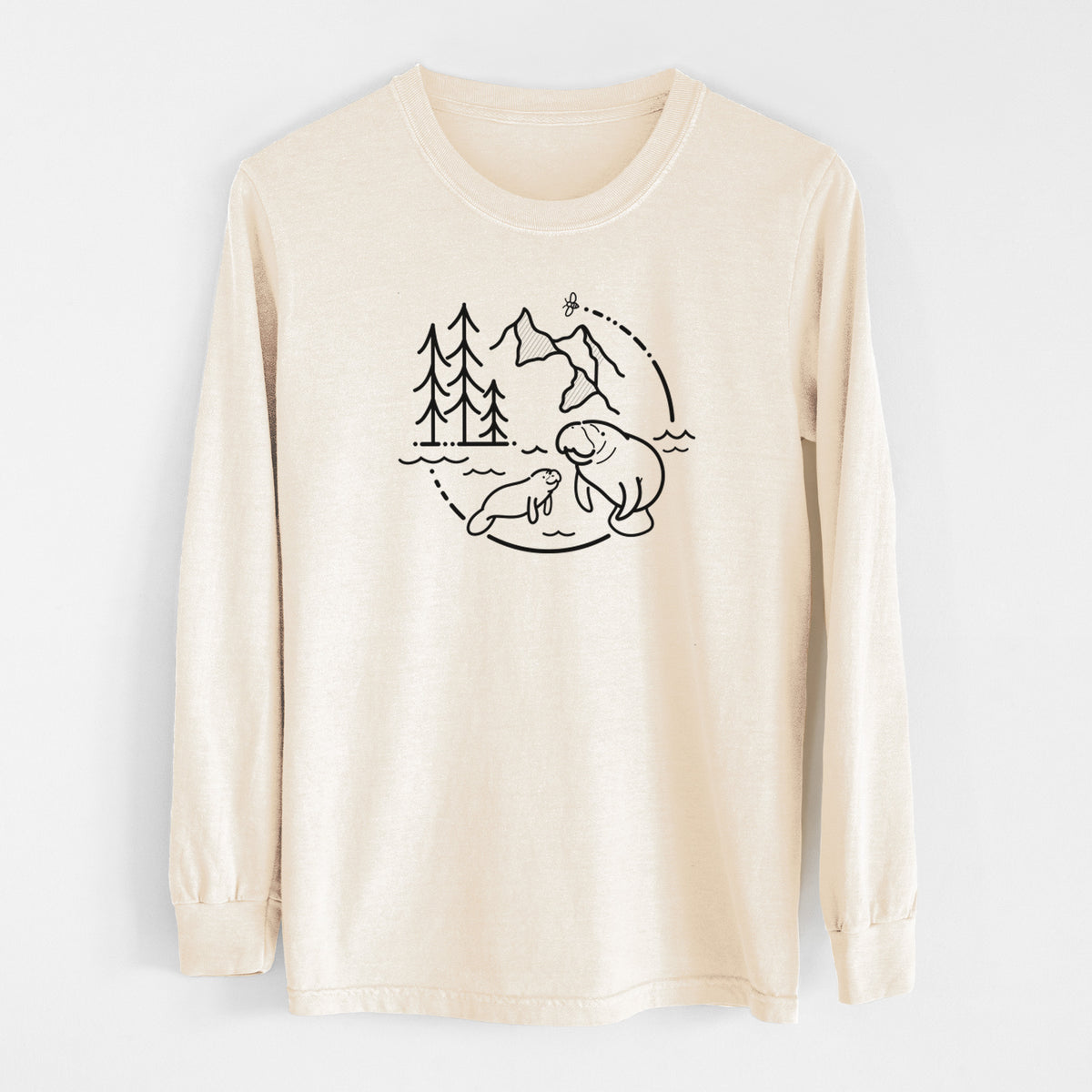 Ivory Comfort Colors long sleeve shirt laid flat, printed with a black line art circle connecting pine trees, mountains, a bee and two manatees swimming in water.