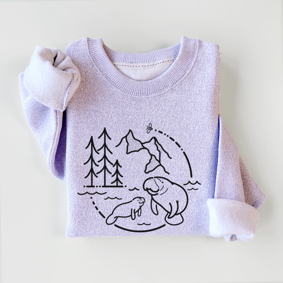Ice purple knit sweatshirt printed with a black line art circle connecting pine trees, mountains, a bee and two manatees swimming in water, styled flat.