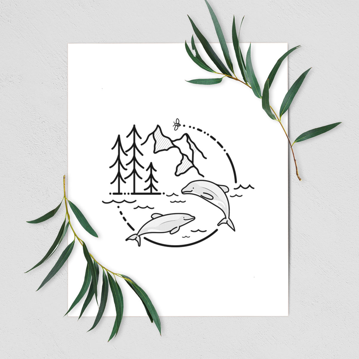 Art print of a black line art circle connecting pine trees, mountains, a bee and two Maui dolphins leaping from the waves, shown with eucalyptus leaves.
