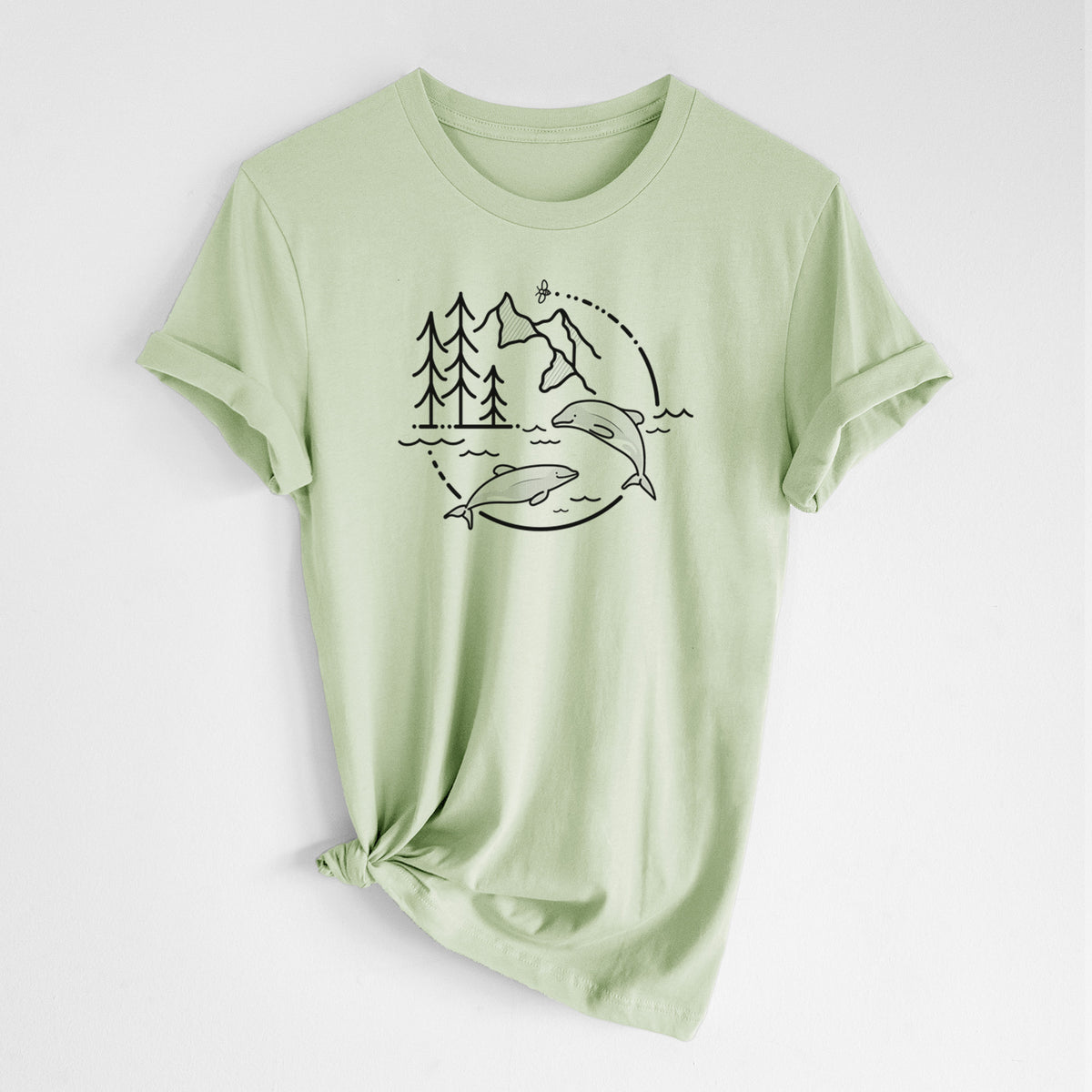Spring green lightweight cotton t-shirt laid flat with the sleeves rolled, printed with a black line art circle connecting pine trees, mountains, a bee and two Maui dolphins leaping from the waves.