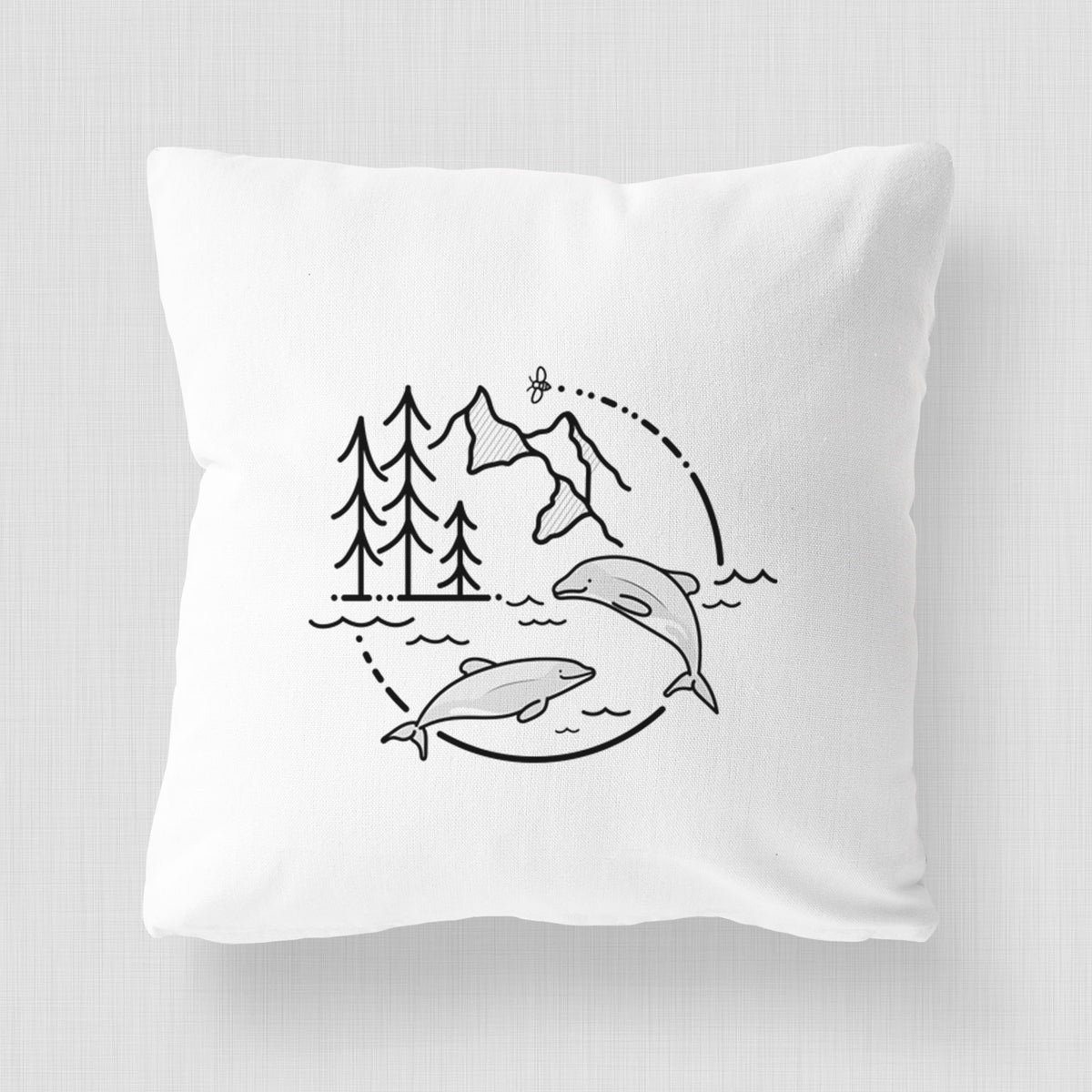 White pillow cover printed with a black line art circle connecting pine trees, mountains, a bee and two Maui dolphins leaping from the waves.