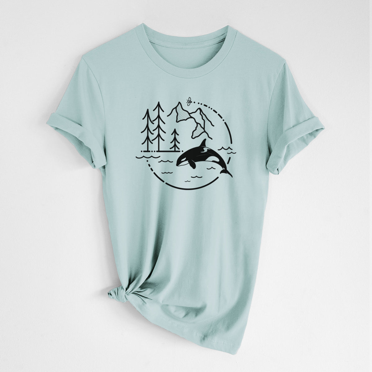 Dusty blue lightweight cotton t-shirt laid flat with the sleeves rolled, printed with a black line art circle connecting pine trees, mountains, a bee and an orca leaping from ocean waves.