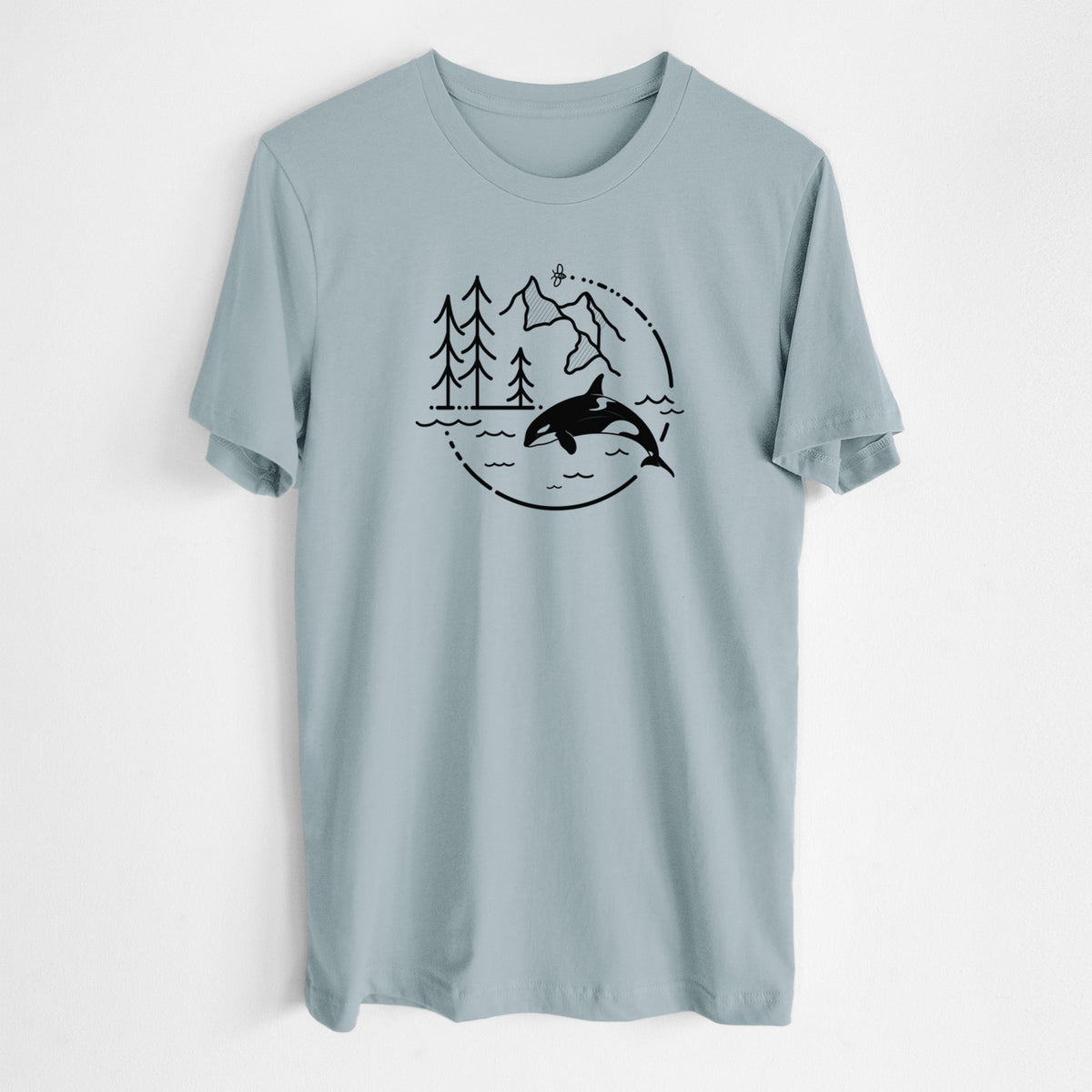 Vintage denim lightweight cotton t-shirt laid flat, printed with a black line art circle connecting pine trees, mountains, a bee and an orca leaping from ocean waves.