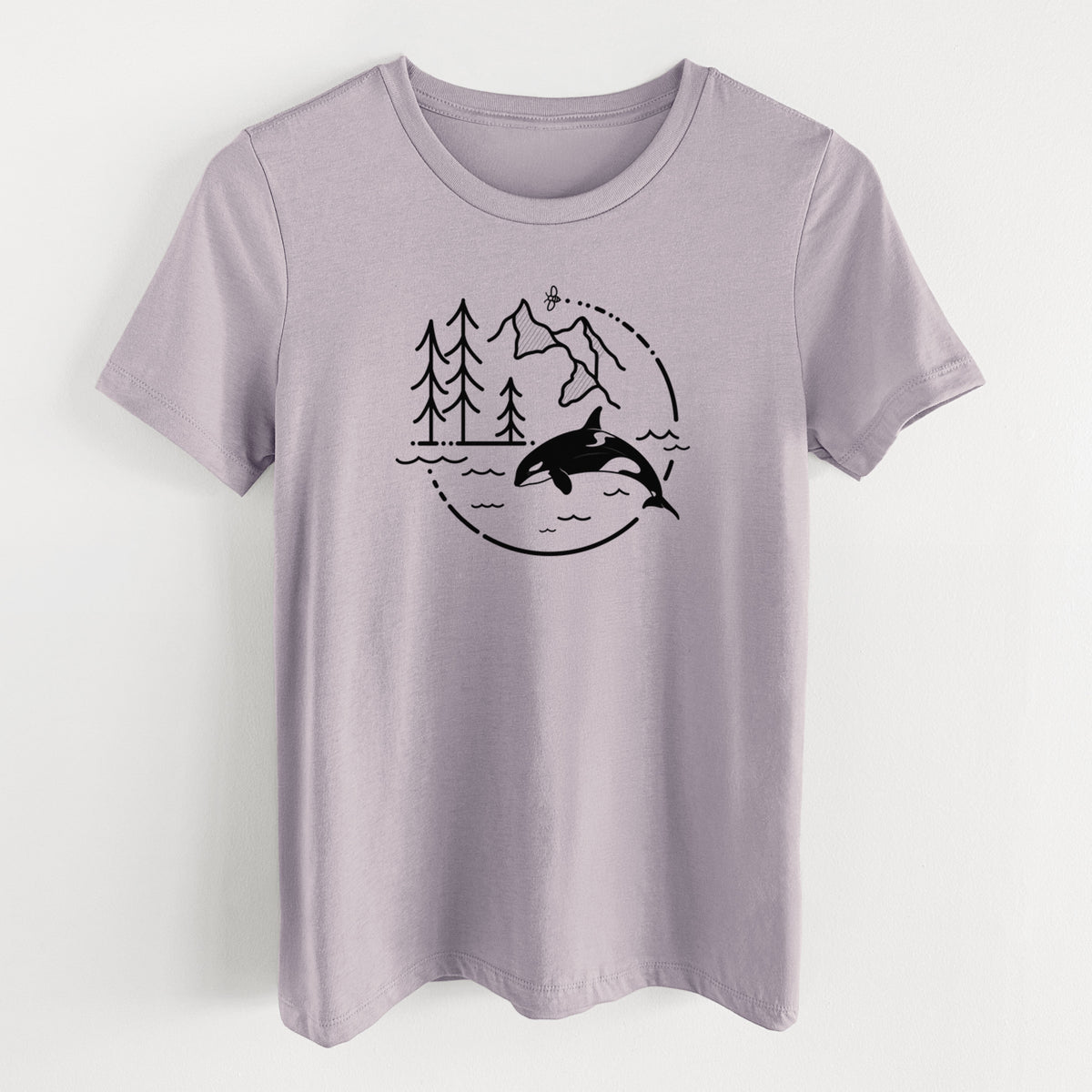 Light violet women's relaxed fit cotton t-shirt laid flat, printed with a black line art circle connecting pine trees, mountains, a bee and an orca leaping from ocean waves.