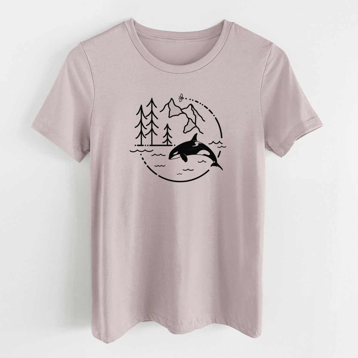 Pink gravel women's relaxed fit cotton t-shirt laid flat, printed with a black line art circle connecting pine trees, mountains, a bee and an orca leaping from ocean waves.