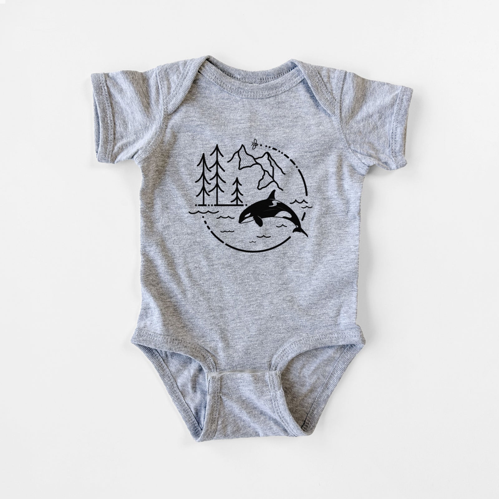 Grey baby bodysuit laid flat, printed with a black line art circle connecting pine trees, mountains, a bee and an orca leaping from ocean waves.