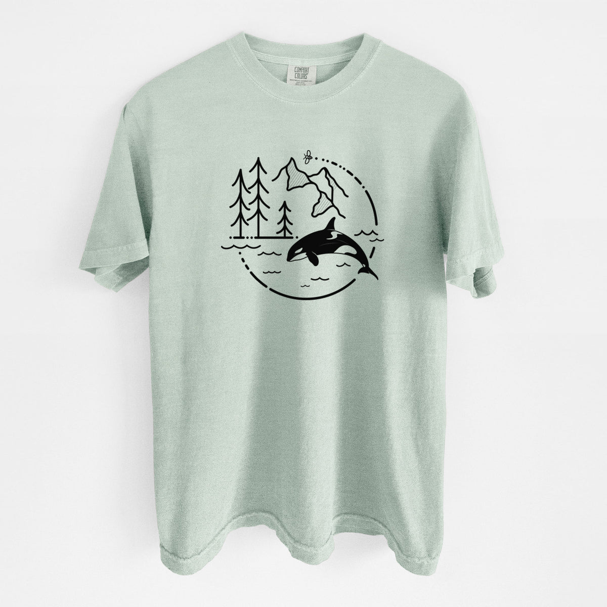 Bay green Comfort Colors t-shirt laid flat, printed with a black line art circle connecting pine trees, mountains, a bee and an orca leaping from ocean waves.