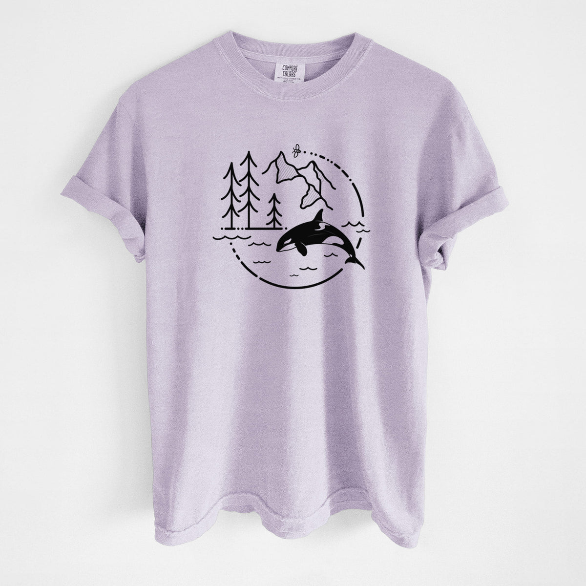 Orchid purple Comfort Colors t-shirt laid flat, printed with a black line art circle connecting pine trees, mountains, a bee and an orca leaping from ocean waves.