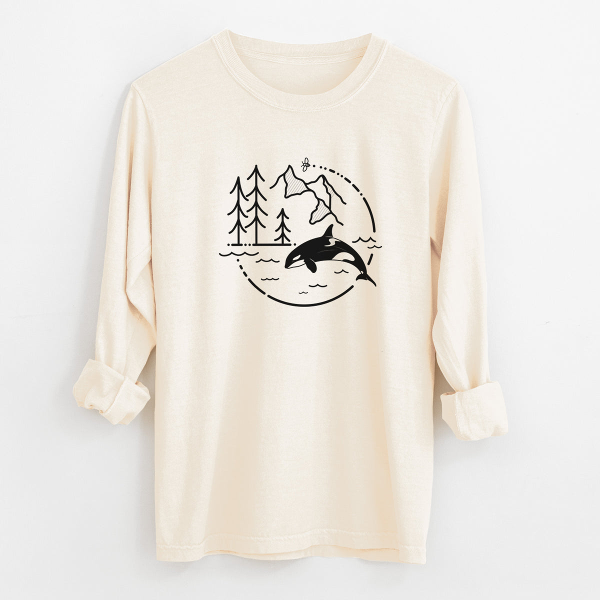 Ivory Comfort Colors long sleeve shirt laid flat with the cuffs rolled, printed with a black line art circle connecting pine trees, mountains, a bee and an orca leaping from ocean waves.