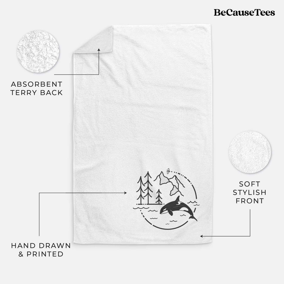 White hand towel printed with a black line art circle connecting pine trees, mountains, a bee and an orca leaping from ocean waves.