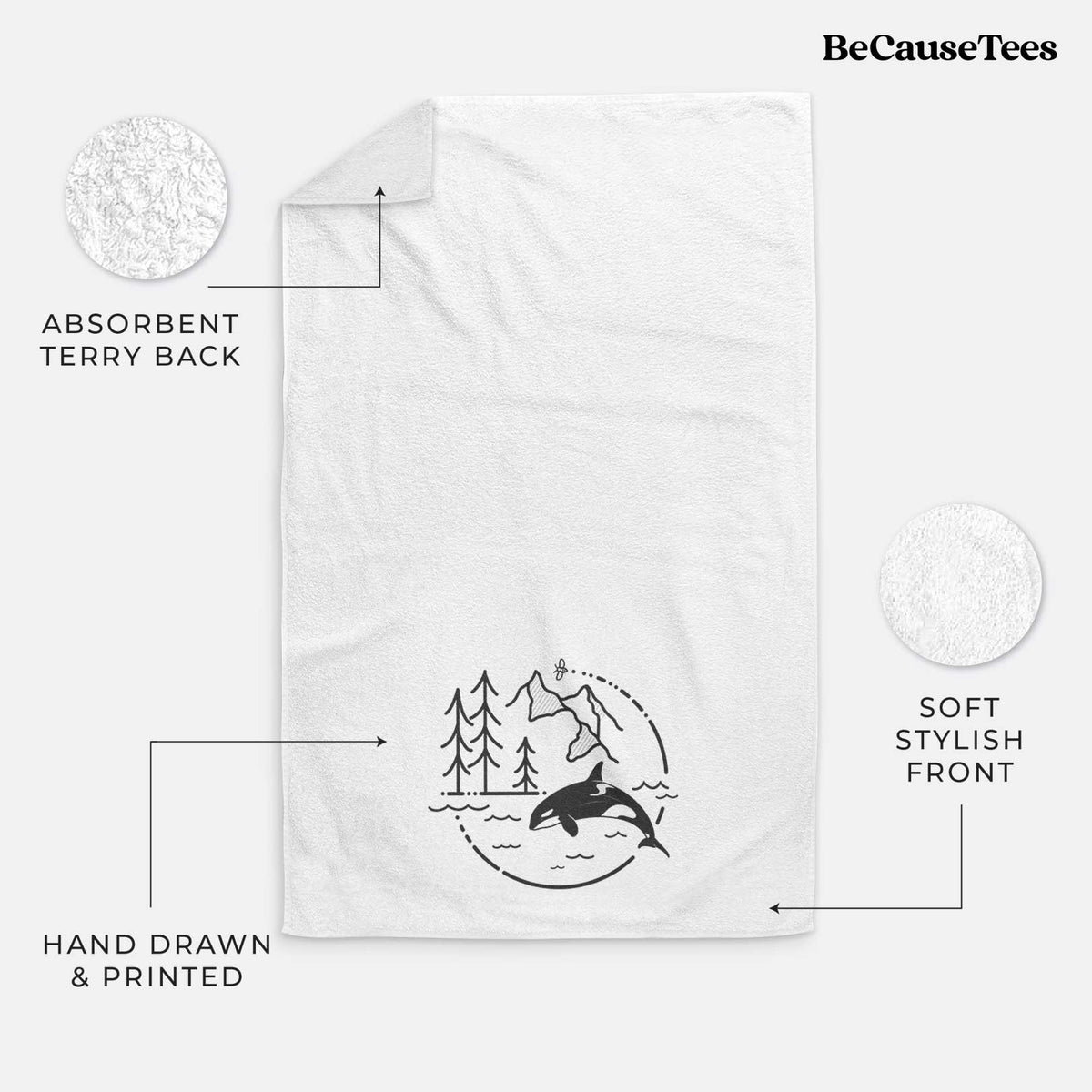 White hand towel printed with a black line art circle connecting pine trees, mountains, a bee and an orca leaping from ocean waves.