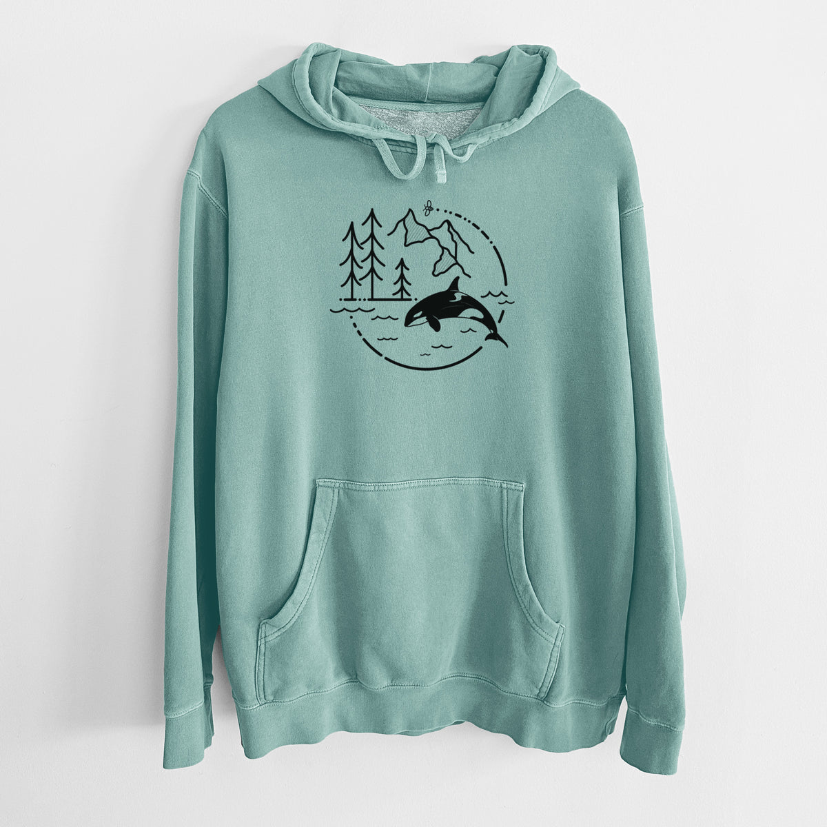 Mint green pigment dyed hoodie laid flat, printed with a black line art circle connecting pine trees, mountains, a bee and an orca leaping from ocean waves.