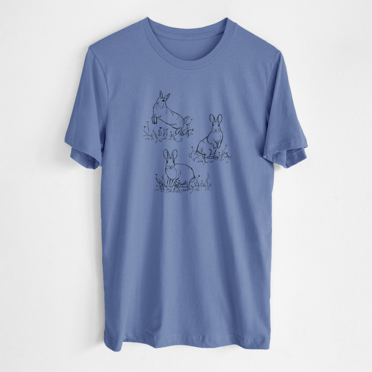 Blue bell lightweight cotton t-shirt laid flat, printed with a black ink illustration of three cottontail rabbits among grass and flowers.