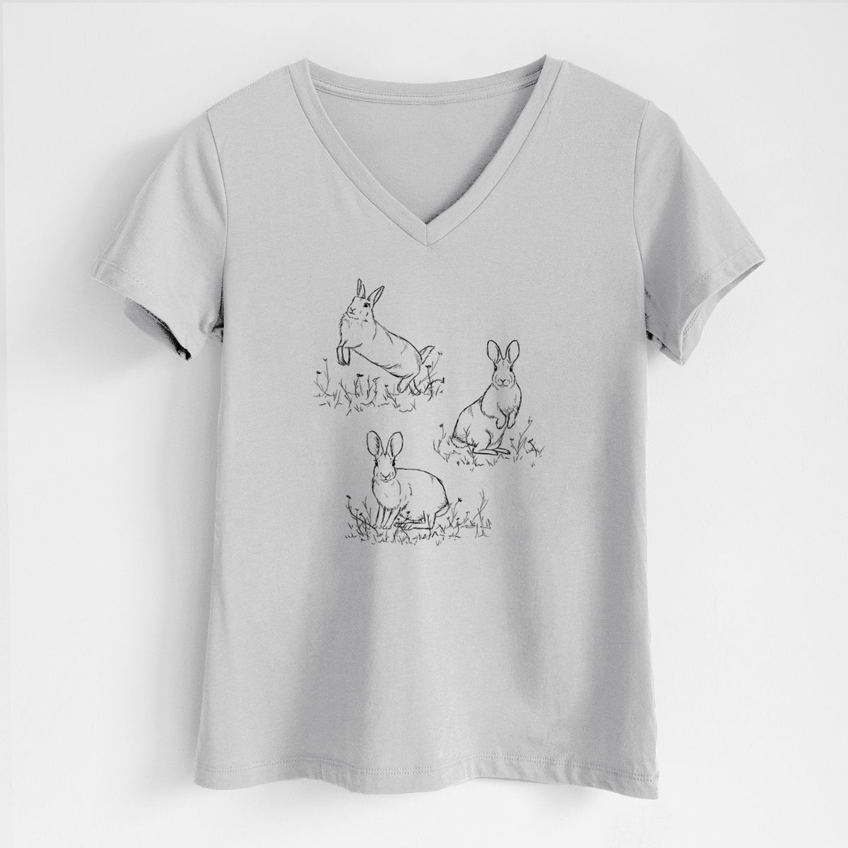 Lunar grey women's relaxed fit cotton V-neck t-shirt laid flat, printed with a black ink illustration of three cottontail rabbits among grass and flowers.